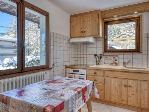 - une cuisine avec une table et un évier ainsi que 2 fenêtres dans l'établissement Charmant 2 pièces à Megève, proche du centre et des télécabines, avec balcon et parking - FR-1-453-120, à Megève