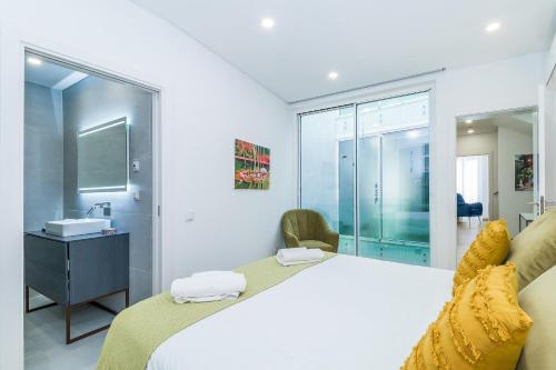 1 Schlafzimmer mit einem großen Bett und einem Badezimmer in der Unterkunft Vista Bonita by Algarve Golden Properties in Lagos