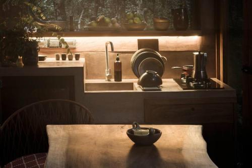 a kitchen with a table with a bowl on it at OJO DE AGUA. Design+pool. Vive la auténtica selva! in Tulum