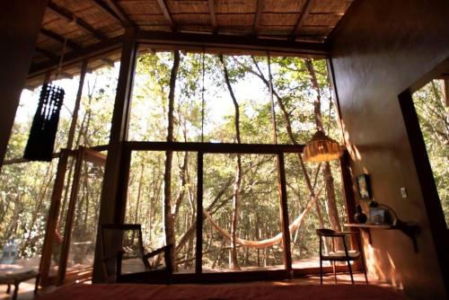 a room with a large window with trees outside at OJO DE AGUA. Design+pool. Vive la auténtica selva! in Tulum