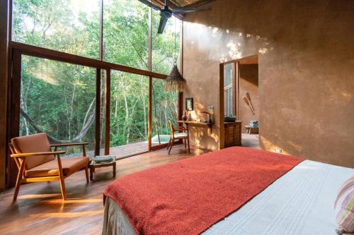 a bedroom with a bed and a large window at OJO DE AGUA. Design+pool. Vive la auténtica selva! in Tulum