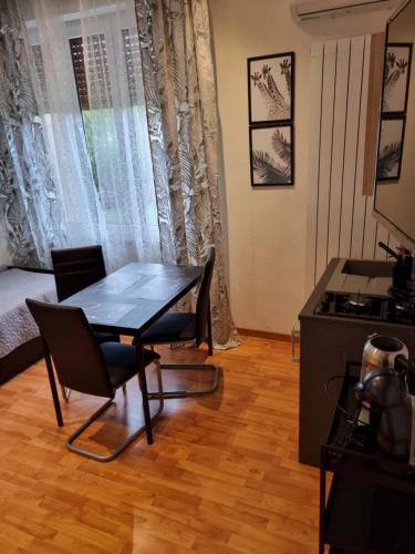 ein Esszimmer mit einem Tisch, Stühlen und einem Bett in der Unterkunft Alloggio Orchidea in Monfalcone