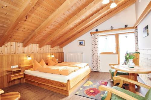 1 dormitorio con cama y techo de madera en Landhaus Maltermoos, en Schönau am Königssee