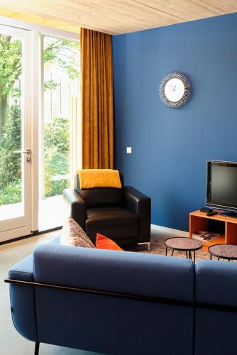 a blue living room with a couch and a chair at Achterhoeks Goed in Lichtenvoorde-Vragender in Vragender