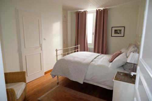a bedroom with a bed and a window at Au Chiron in Néré
