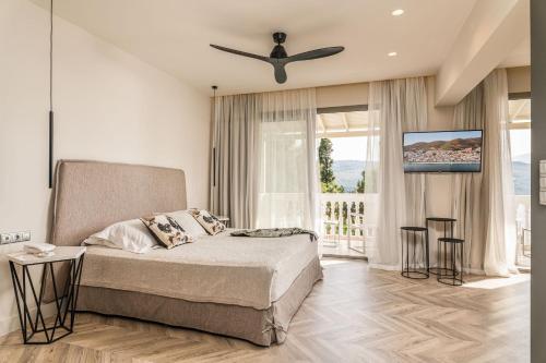 a bedroom with a bed and a ceiling fan at Ino Hotel & Suites in Samos