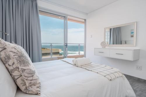 een slaapkamer met een groot bed en uitzicht op de oceaan bij 401 Bermuda Endless ocean views in Ballito