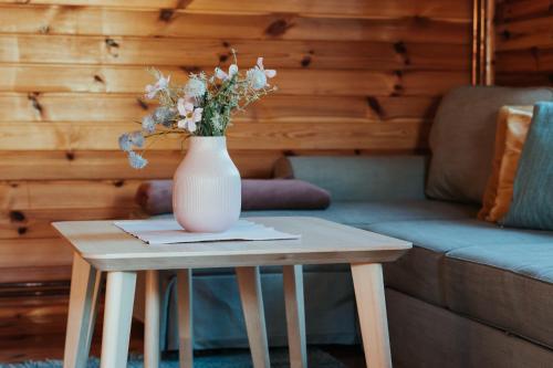 a vase of flowers sitting on a table next to a couch at HORBACZÓWKA in Czerwonki