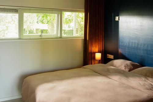 a bedroom with a large bed and a window at Achterhoeks Goed, Bed & Breakfast in Vragender in Vragender