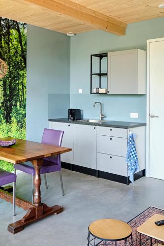 a kitchen with a wooden table and purple chairs at Achterhoeks Goed in Lichtenvoorde-Vragender in Vragender
