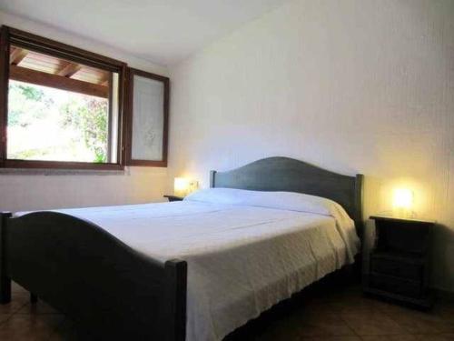 una camera con un grande letto e una finestra di Villa Azzurra a Tertenìa