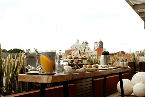 a table with food and drinks on a balcony at Casa Azulai Puebla Hotel Boutique in Puebla