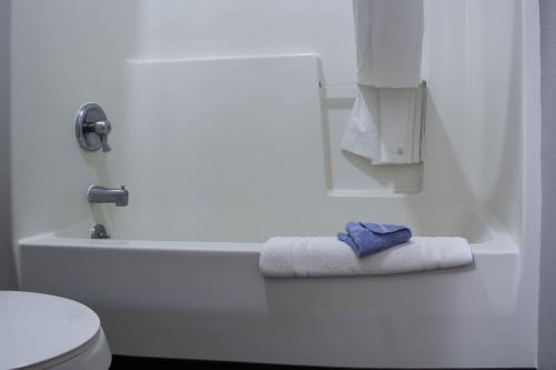 a bathroom with a white bath tub and a towel at New Victorian Inn & Suites-Norfolk in Norfolk
