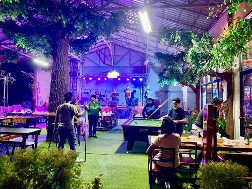 eine Gruppe von Menschen, die eine Partie Billard in einem Restaurant spielen in der Unterkunft เรือนร่มไม้รีสอร์ท RuenRomMai Resort in Ban Klang Mun