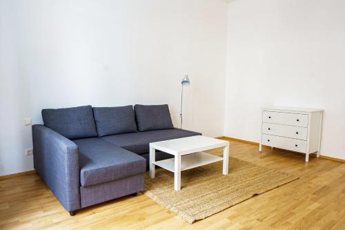 a living room with a blue couch and a table at Vienna City Apartments Ottakring in Vienna