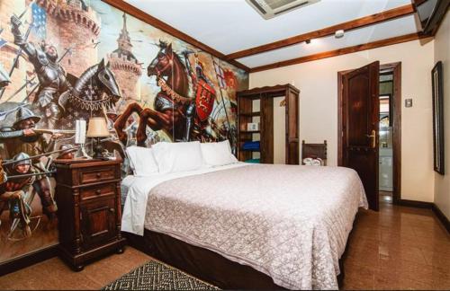 a bedroom with a large bed and a painting on the wall at Castillo Medieval in Viña del Mar