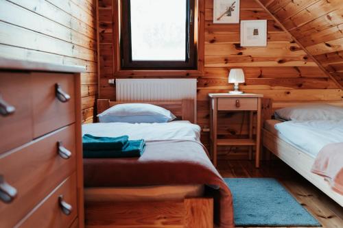1 dormitorio con 2 camas en una cabaña de madera en HORBACZÓWKA, en Czerwonki