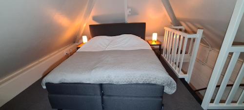a small bed in a room with a staircase at Marry's boshuisje in Dalfsen