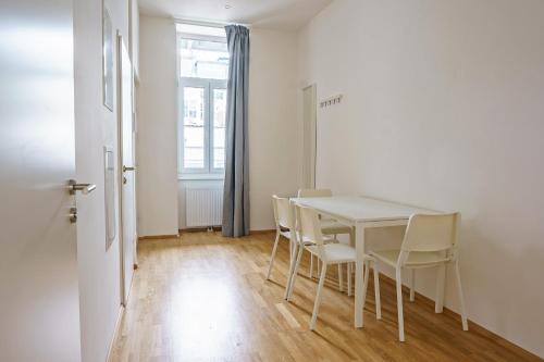 a dining room with a white table and chairs at Vienna City Apartments Ottakring in Vienna