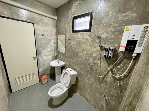 uma casa de banho com um chuveiro, um WC e um lavatório. em ดีต่อใจ รีสอร์ท เชียงม่วน Deetorjai Resort em Chiang Muan