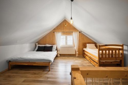 Schlafzimmer im Dachgeschoss mit 2 Betten und einem Fenster in der Unterkunft Apartmány Pod Šerákem in Lipová-lázně