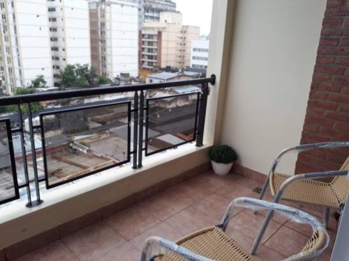 a balcony with two chairs and a view of a city at Muy agradable departamento. Bien ubicado, luminoso in San Miguel de Tucumán