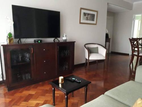 una sala de estar con un gran centro de entretenimiento con TV de pantalla plana en Muy agradable departamento. Bien ubicado, luminoso en San Miguel de Tucumán