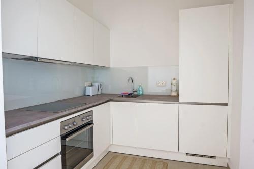 a white kitchen with white cabinets and a sink at Vienna City Apartments Ottakring in Vienna