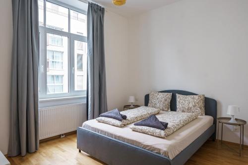 Un dormitorio con una cama con almohadas azules. en Vienna Living Apartments - Ottakring en Viena