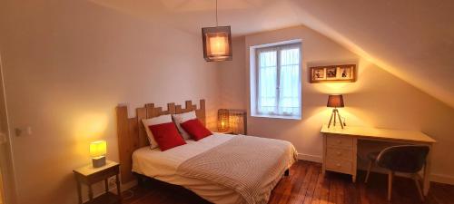 a bedroom with a bed with red pillows and a window at Maison tout confort avec jardin - CHANTILLY, SENLIS, PARC ASTERIX, PARIS CDG in Avilly-Saint-Léonard