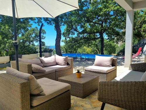 奧米什的住宿－Holiday Home Hrstic，庭院设有藤椅和遮阳伞。