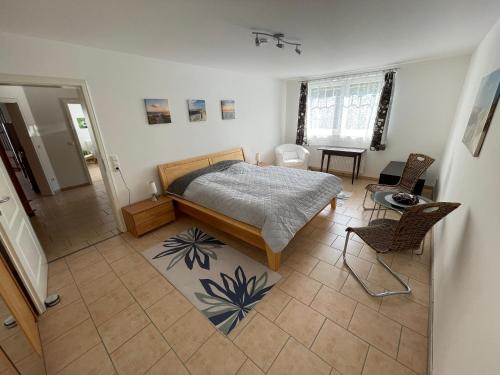 1 dormitorio con 1 cama y 2 sillas en Villa Fuchsbau, en Hohenfelde