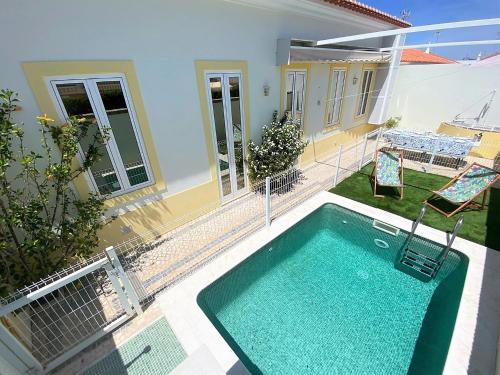 a swimming pool in the backyard of a house at Casa do Mar Salgado in Vila Nova De Cacela