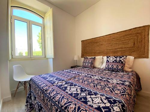 - une chambre avec un grand lit et une fenêtre dans l'établissement Casa do Mar Salgado, à Vila Nova De Cacela