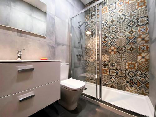 ein Badezimmer mit Dusche, Toilette und Waschbecken in der Unterkunft Casa do Mar Salgado in Vila Nova De Cacela