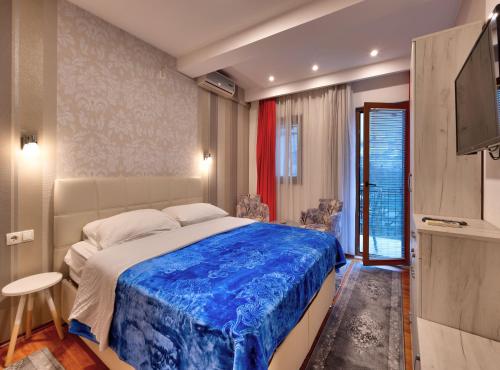 - une chambre avec un grand lit et une couverture bleue dans l'établissement Pansion Villa Nur, à Mostar