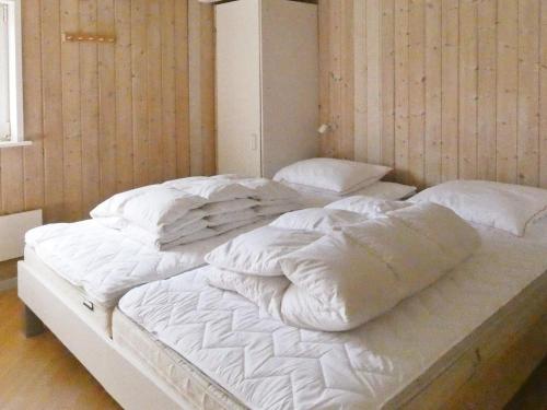 a large bed with white sheets and pillows on it at 10 person holiday home in Løkken-By Traum in Løkken