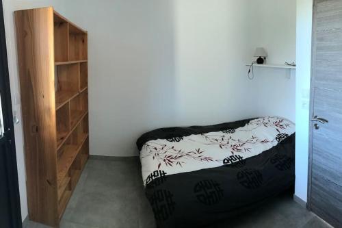 une chambre avec un lit et une étagère dans l'établissement T1 traversant, plain pied entre mer et montagne, à Cuttoli-Corticchiato