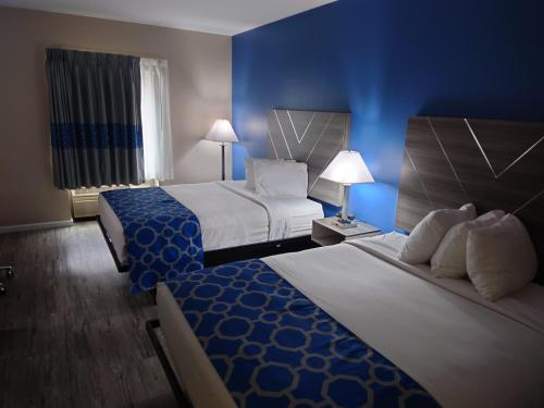 2 camas en una habitación de hotel con paredes azules en Baymont by Wyndham Adairsville, en Adairsville