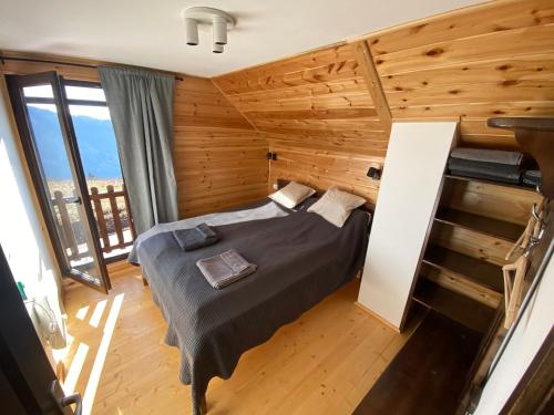 a bedroom with a bed in a room with wooden walls at Zlatar Lake Hill in Nova Varoš