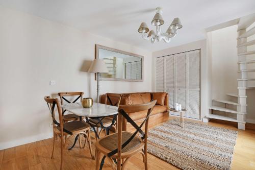 een woonkamer met een tafel en stoelen en een bank bij Amazing duplex 4P- Louvre Museum Tuileries in Parijs