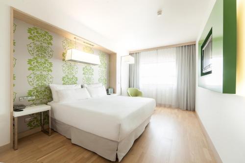 a bedroom with a large white bed and a window at Occidental Praha Five in Prague