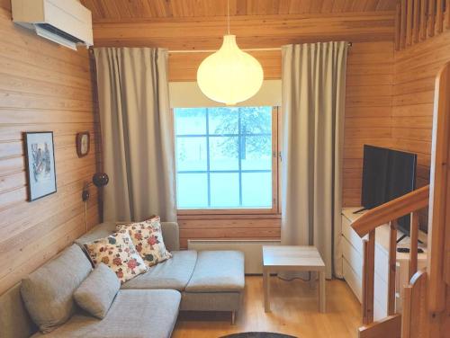 a living room with a couch and a window at Gold Legend Paukkula #4 - Saariselkä Apartments in Saariselka
