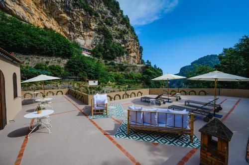 eine Terrasse mit Tischen, Stühlen und Sonnenschirmen in der Unterkunft The Lemon Garden by Elite Villas in Pontone