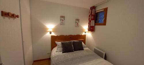 a bedroom with a bed with two pillows on it at Skis aux pieds dans un appartement cosy au coeur du Queyras in Molines-en-Queyras