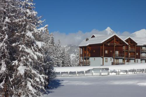 a lodge in the snow with snow covered trees at Skis aux pieds dans un appartement cosy au coeur du Queyras in Molines-en-Queyras