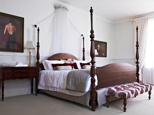 a bedroom with a large bed with a wooden frame at Parkes Manor in Knysna