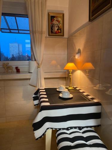 een kamer met een tafel met een lamp en een raam bij Studio PANORAMIC in Alba Iulia