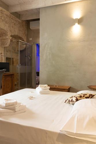a bedroom with a white bed with towels on it at Graffiti Living - Santa Rita - Rooms in Corato