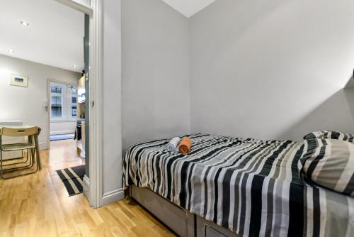a bedroom with a bed with a black and white comforter at Main Street Corner Great 1bedroom Flat - Richmond in London